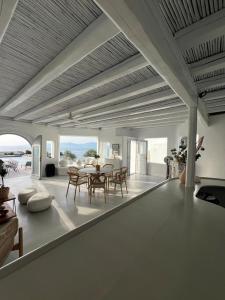 Villa Amarone في مدينة ميكونوس: غرفة معيشة كبيرة مع طاولة وكراسي