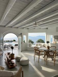 Villa Amarone في مدينة ميكونوس: غرفة معيشة بها طاولة وكراسي