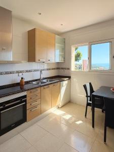 a kitchen with a table and a sink and a stove at Villa Irene - Vistas al mar in Lloret de Mar