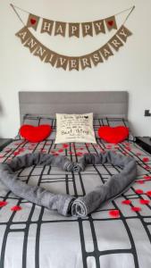 ロンドンにあるLuxury apartment steps from Battersea Power ST and close to Victoria & Chelseaの赤い椅子と新年おめでとうの看板が置かれたベッド