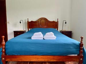 two towels stacked on a bed with blue sheets at Azul 31 in Lajes das Flores +5 photos