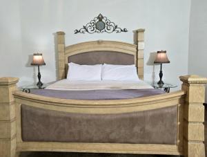 ein Schlafzimmer mit einem großen Holzbett mit zwei Lampen in der Unterkunft NEW Pool, Patio, Pickleball, Cornhole, Hot Tub in Fredericksburg + 34 Fotos