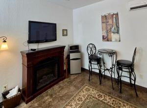 ein Wohnzimmer mit einem Kamin und einem Flachbild-TV in der Unterkunft NEW Pool, Patio, Pickleball, Cornhole, Hot Tub in Fredericksburg