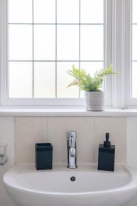 a sink in a bathroom with a window at The Romford Oasis - Spacious 4 bedroom escape in Havering atte Bower +68 photos