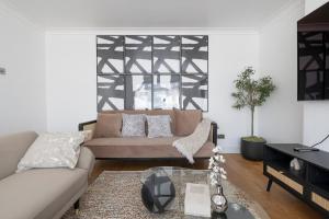 a living room with a couch and a table at The Romford Oasis - Spacious 4 bedroom escape in Havering atte Bower