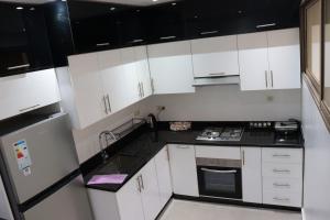 a kitchen with white cabinets and black counter tops at appartement 3 chambres gueliz only families in Marrakech