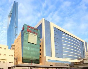 un grand bâtiment avec un panneau sur son côté dans l'établissement Ibis Riyadh Olaya Street, à Riyad