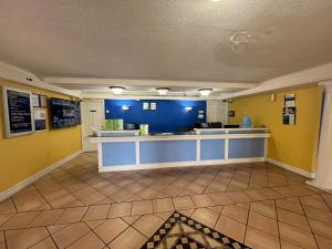 a lobby with yellow and blue walls and a counter at Studio 6 Huntsville, AL University Drive in Huntsville