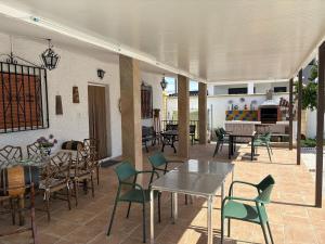 a patio with tables and chairs and a kitchen at Villa La Loma del Viento in Belicena
