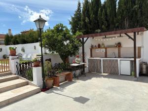 a backyard with a kitchen and a patio with a table at Villa La Loma del Viento in Belicena