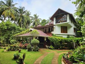a house with a garden in front of it at Maleyam Homestay in Kozhikode