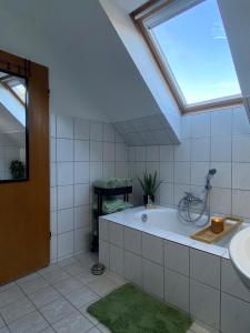 a bathroom with a tub and a sink and a window at Ferienwohnung am Freibad in Emden
