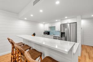 eine Küche mit einer großen weißen Theke und Stühlen in der Unterkunft 1351 Fairway Oaks Villa by Akers Ellis Rentals in Kiawah Island