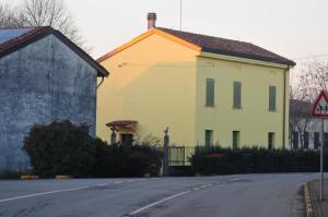 una grande casa gialla sul lato di una strada di Foresteria due Galli a San Martino del Lago