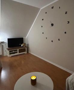 a living room with a clock on the wall at Ferienwohnung am Freibad in Emden +30 photos