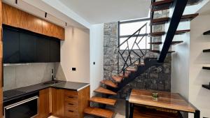 a kitchen with a spiral staircase in a house at Durmitor Summit in Žabljak