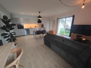a living room with a black couch and a table at Esprit Cosy in Saint-Laurent-de-Chamousset