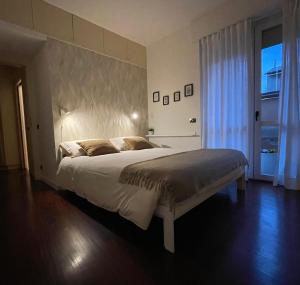 a bedroom with a large bed with a large headboard at La casa di Erika in Almè