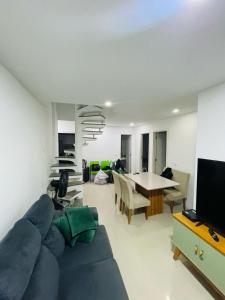 salon z niebieską kanapą i stołem w obiekcie Aluguel de Apartamento em Cabo Frio Temporada e Finais de Semana w mieście Cabo Frio