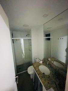 łazienka z umywalką, toaletą i lustrem w obiekcie Aluguel de Apartamento em Cabo Frio Temporada e Finais de Semana w mieście Cabo Frio +9 zdjęć