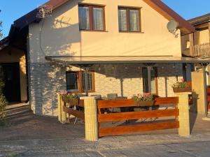 a house with a wooden bench in front of it at FoRest in Bystrzyca