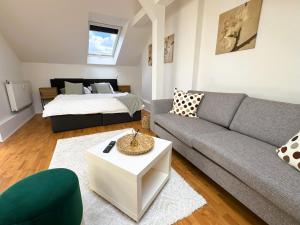 a living room with a couch and a bed at Loftstyle Wohnung in Wiesbaden in Wiesbaden