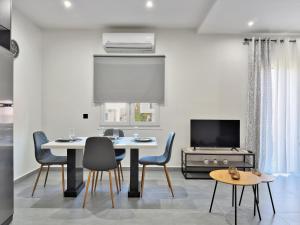 KiladaにあるKilada Luxury Apartment 1のテーブルと椅子とテレビのあるダイニングルーム