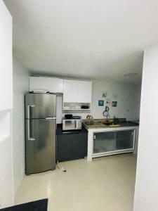 W kuchni znajduje się lodówka ze stali nierdzewnej i kuchenka mikrofalowa. w obiekcie Aluguel de Apartamento em Cabo Frio Temporada e Finais de Semana w mieście Cabo Frio