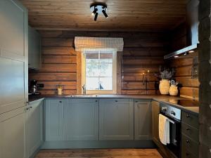 a kitchen with a sink and a window at Sentrumsnær Røroshytte in Røros