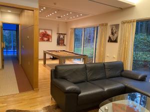 a living room with a leather couch and a pool table at Kakumäe Raba Villa - Luxury Private Spa Villa in Tallinn in Tallinn +46 photos