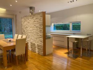 a kitchen and dining room with a stone wall at Kakumäe Raba Villa - puhkemaja basseiniga Tallinnas in Tallinn