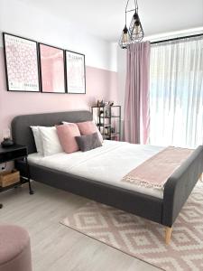 ein Schlafzimmer mit einem großen Bett mit rosa Wänden in der Unterkunft Wanderlust Home Pink, Rasnov Apt for 4, Wifi and Free Parking in Râșnov