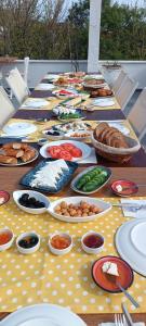 a long table with plates of food on it at Bozcaada Su otel in Bozcaada