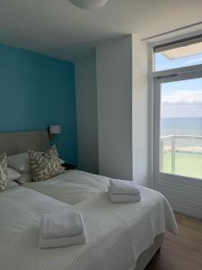 een slaapkamer met een groot bed met een groot raam bij Sunset Beach in Zandvoort