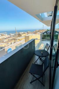 un balcone con due sedie e un tavolo e l'oceano di PRO HOME Balmaceda IV ad Antofagasta