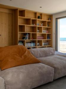 un soggiorno con divano e libreria di La villa de la plage a Mauguio Altre 45 foto
