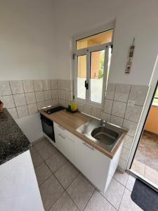a small kitchen with a sink and a window at Apartment Piranesi with a parking space in Pula