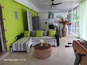 a living room with a couch and a table at Villa BEAUCI-TURLET in Goyave