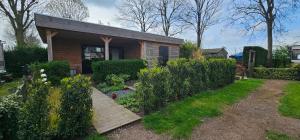 a small house with a wooden walkway in a garden at Ben's Cabine - De Hollandse Boerderij in Bodegraven