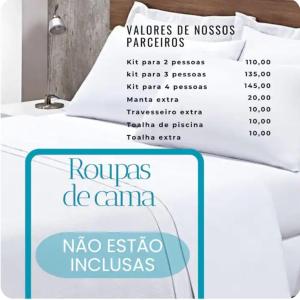 a bed with a pillow with a sign on it at Spazzio 631 Diroma COM CLUBE GRATIS TODO DIA in Caldas Novas