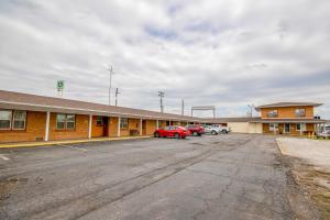 Un edificio con coches aparcados en un estacionamiento. en OYO Travelier Motel, en Macon