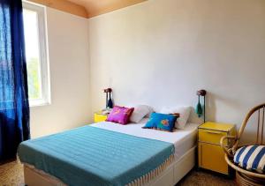 a bedroom with a bed with colorful pillows on it at Large house & swimming pool in downtown Arles in Arles
