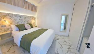 ein weißes Schlafzimmer mit einem großen Bett und einem Marmorboden in der Unterkunft Guayarmina 201 in Mogán