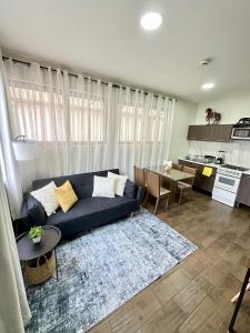 een woonkamer met een blauwe bank en een keuken bij Departamento Roma 1 CDMX in Mexico-Stad