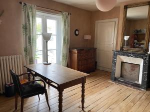 ein Wohnzimmer mit Tisch und Kamin in der Unterkunft Chambres à louer centre-ville in Le Mans + 25 Fotos
