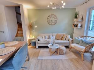 a living room with a couch and a table at Düne 4 - Ferienunterkunft mit eigenem Garten in der beliebten Dünenresidenz - sanftes Meeresrauschen inklusive in Karlshagen