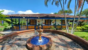 a house with a fountain in front of it at San Antonio in Quimbaya