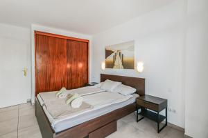 ein Schlafzimmer mit einem großen Bett mit einem hölzernen Kopfteil in der Unterkunft Aguila Playa Beach Escape in Maspalomas