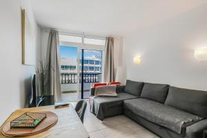 ein Wohnzimmer mit Sofa und Tisch in der Unterkunft Aguila Playa Beach Escape in Maspalomas