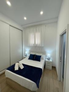 a bedroom with a large bed with blue pillows at Apartamento Plaza España in Fuengirola